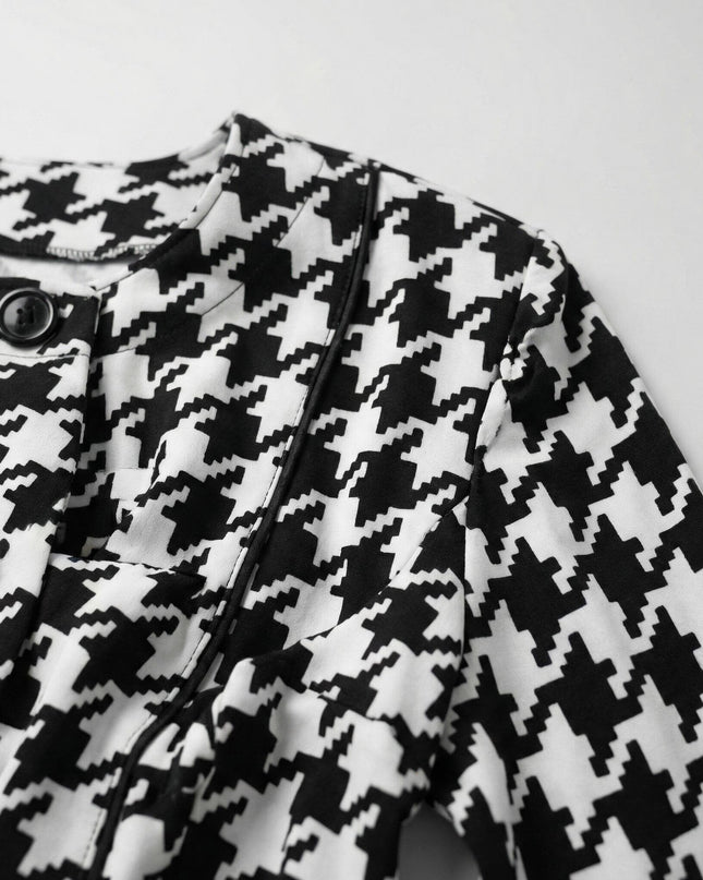 Близък план на официално дамско сако пепит в бяло, показващ детайли на яката, черните копчета и текстурата на материята.