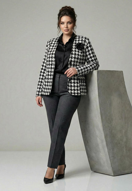 Елегантно дамско сако в пепит с черна роза на ревера, представено в цял ръст върху модел, съчетано с официален тъмносив панталон.