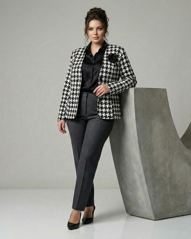 Елегантно дамско сако в пепит с черна роза на ревера, представено в цял ръст върху модел, съчетано с официален тъмносив панталон.