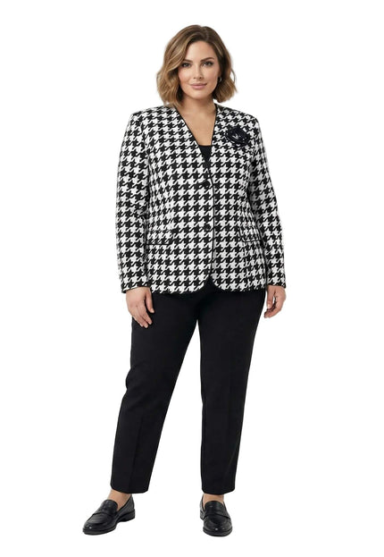 Официално дамско сако в черно-бял пепит с декоративна роза и черен кант, представено в цял ръст върху модел с черен панталон.