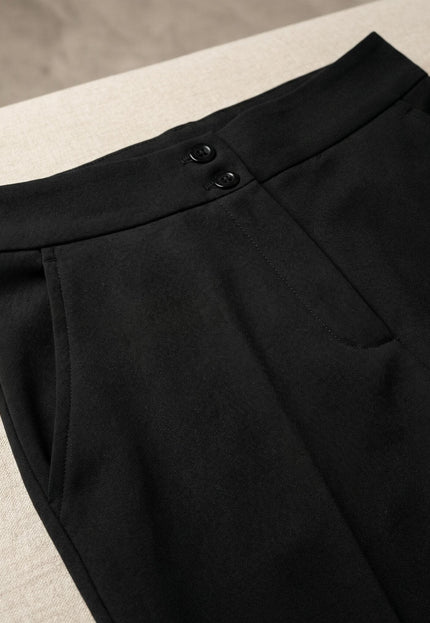 Детайл отблизо на официален черен панталон големи размери с права кройка, показващ високата талия, две копчета и страничен джоб.