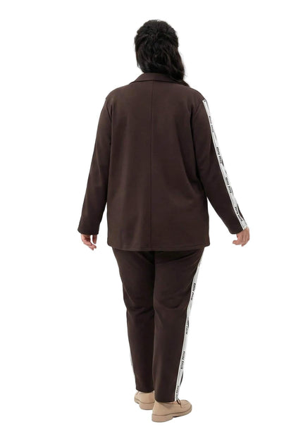 Официален дамски комплект от две части в кафяв цвят, изглед отзад. Сакото и панталонът се отличават с декоративни бели ленти с надписи по страничните ръбове.