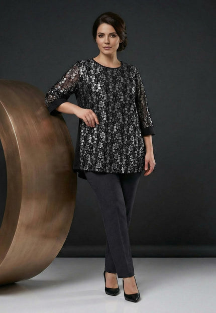 Официална черна макси туника с разкроена кройка и дантела със сребрист блясък, представена в цял ръст върху модел на тъмен фон.