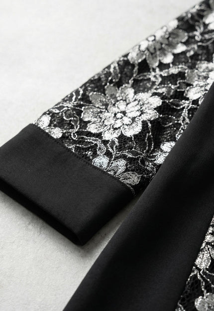 Детайл отблизо на ръкава на официална черна макси туника, показващ изящната флорална дантела и завършващ с елегантен широк маншет.