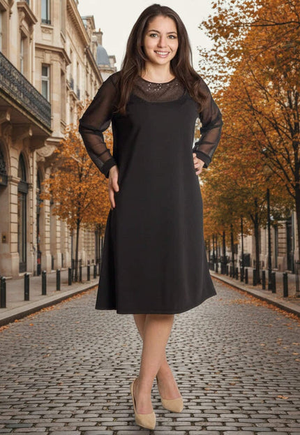 Официална черна рокля с ефирни тюлени ръкави и пайети, представена в цял ръст на фона на есенна улица.