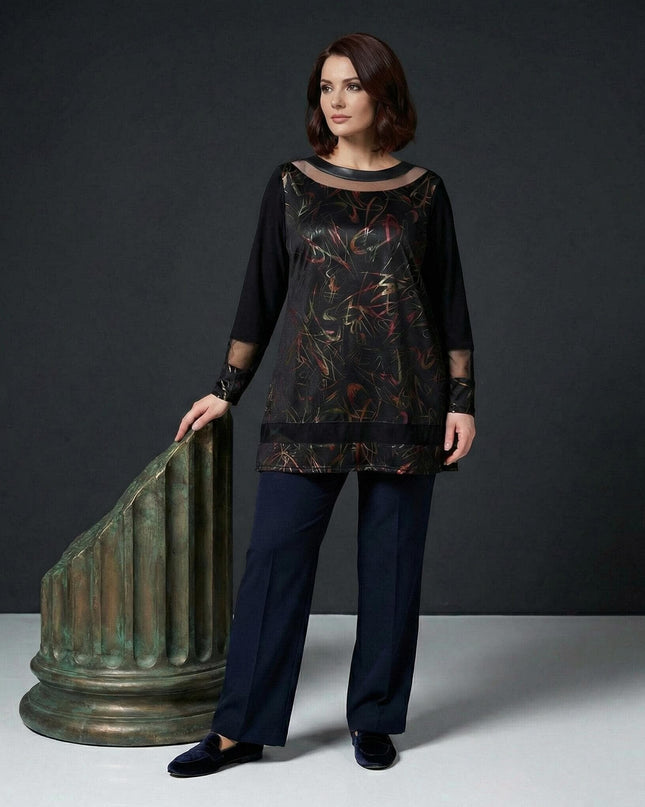 Елегантна черна туника големи размери с абстрактни мотиви и прозрачни елементи, представена в цял ръст до декоративна колона