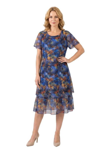 Официална макси рокля от пъстър шифон с разкроен силует в синьо и абстрактен флорален принт, цял ръст на бял фон.