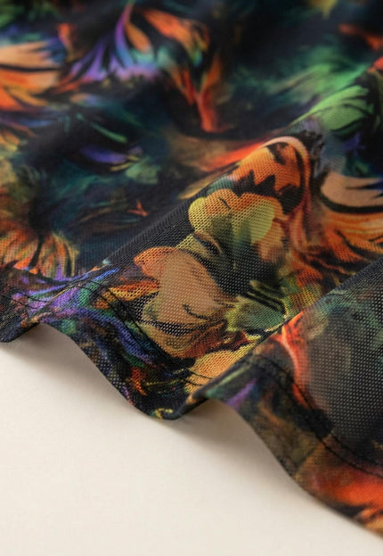 Детайл отблизо на цветната материя на официална макси рокля, показващ фината структура на шифона и качествения шев на подгъва.