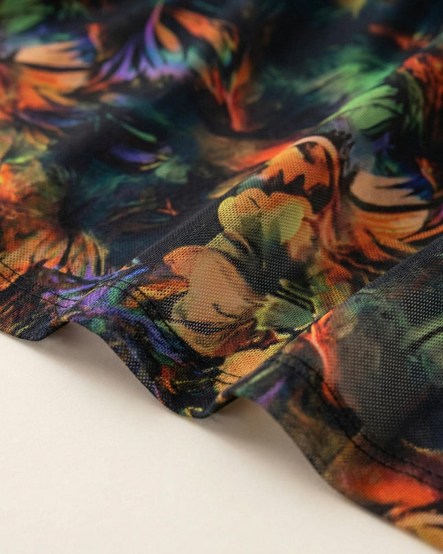 Детайл отблизо на цветната материя на официална макси рокля, показващ фината структура на шифона и качествения шев на подгъва.