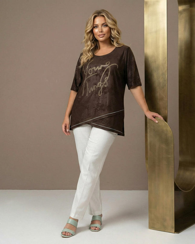 Елегантна кафява макси туника с асиметрична предна част, бял кант и декоративен надпис. Представена в цял ръст върху модел с бял панталон.