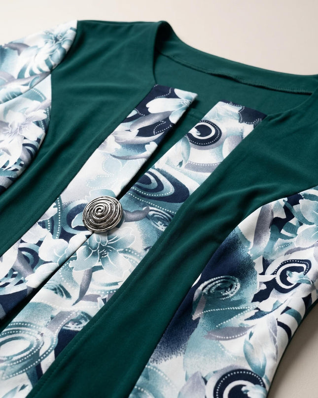 Детайл отблизо на официална масленозелена рокля, показващ красивите флорални мотиви и изящната декоративна метална брошка.