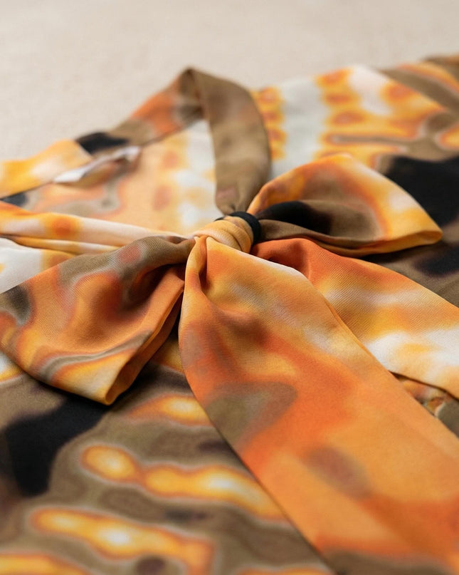 Детайлен кадър отблизо на деколте с елегантна панделка върху официална оранжева туника с абстрактен десен в земни тонове.