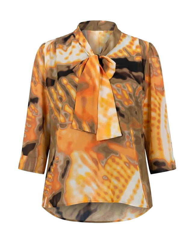 Стилна оранжева туника с абстрактен принт в земни тонове и панделка на деколтето, заснета отпред на бял фон.