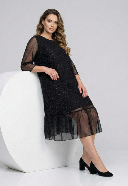 Официална разкроена макси рокля в черно от шифон с камъни и прозрачен волан, заснета в цял ръст до бял декор