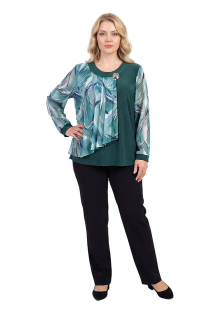 Официална разкроена макси туника в масленозелен цвят с асиметричен шифон на цветя и брошка, показана в цял ръст на бял фон.