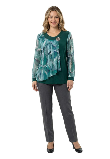 Елегантна макси туника в масленозелено с асиметричен флорален шифон и декоративна брошка, представена в цял ръст върху бял фон.