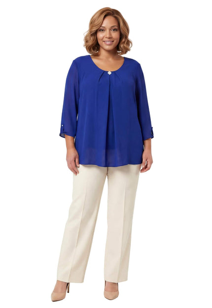 Елегантна разкроена туника от шифон в кралскосин цвят с декоративна брошка на деколтето, показана в цял ръст върху модел.