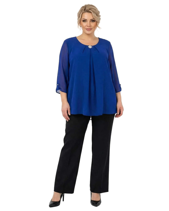 Официална разкроена туника от шифон в кралскосин цвят с брошка, представена върху модел в цял ръст на бял фон.