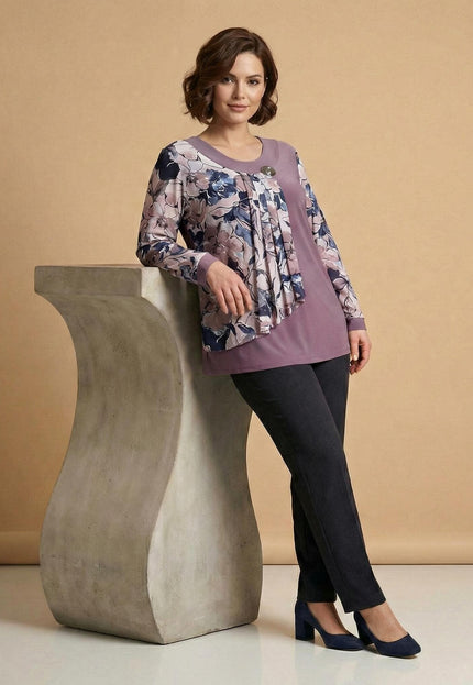 Официална разкроена туника в цвят пепел от рози с ефирен флорален шифон и брошка, заснета върху модел в цял ръст, подпряна на декоративен постамент.