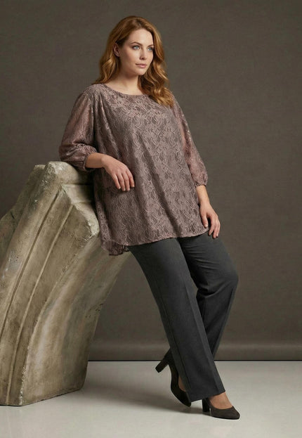 Елегантна разкроена туника от дантела в цвят пепел от рози, съчетана с панталон, представена в цял ръст до декоративна колона.