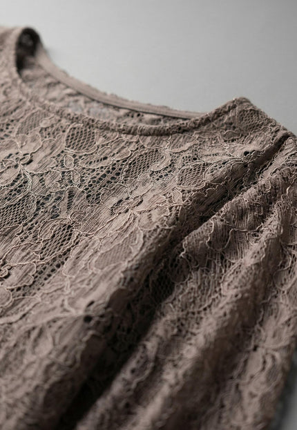 Детайлен кадър на дантелена материя и деколте на официална туника.