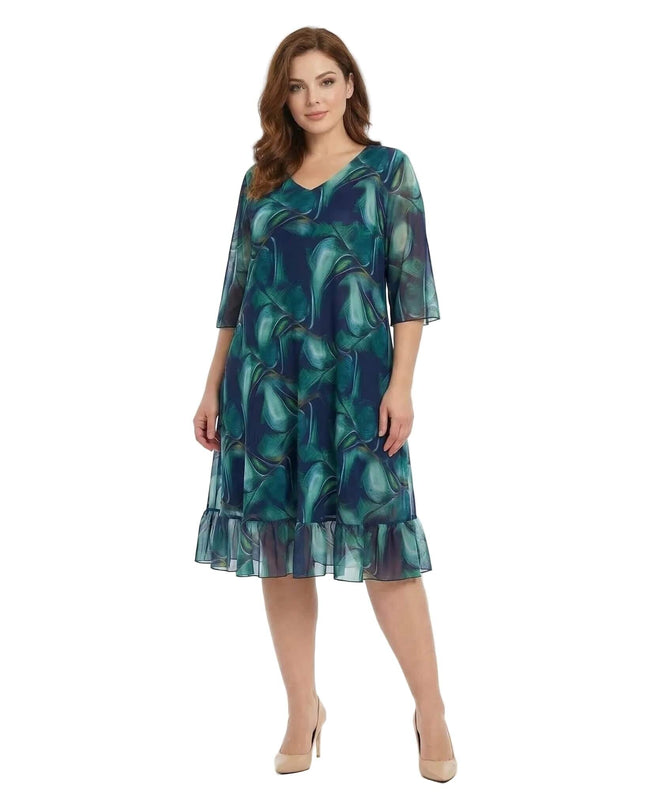 Официална шифонена рокля големи размери в преливащи сини тонове с V-образно деколте и подгъв с волан, заснета отпред в цял ръст на бял фон.