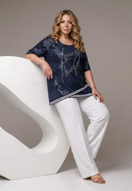 Официална тъмносиня туника големи размери в цял ръст, съчетана с бели панталони на светъл фон.