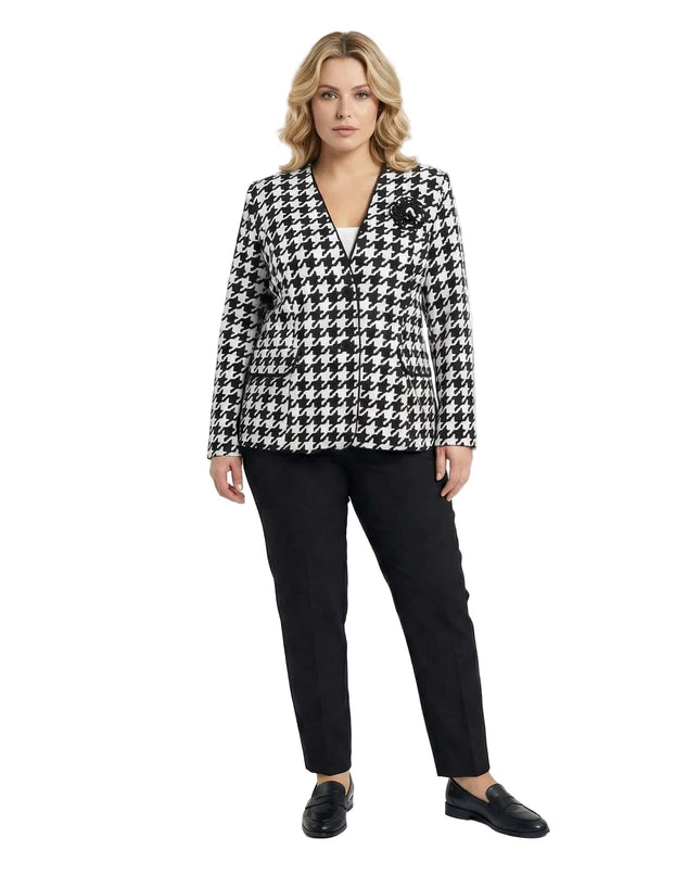 Стилно дамско сако в пепит с декоративна роза и черен кант, представено в цял ръст върху модел с черен панталон.