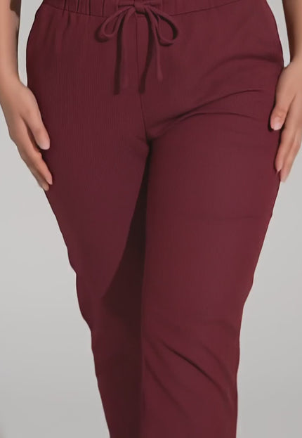 Видео на модел, който върви към камерата и представя Спортно-елегантен макси панталон бордо с прав крачол в студио