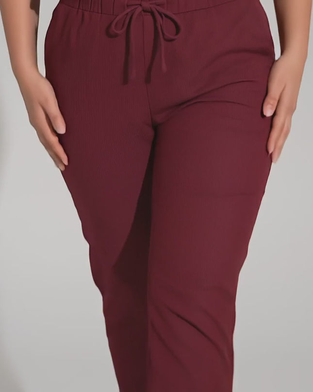 Видео на модел, който върви към камерата и представя Спортно-елегантен макси панталон бордо с прав крачол в студио