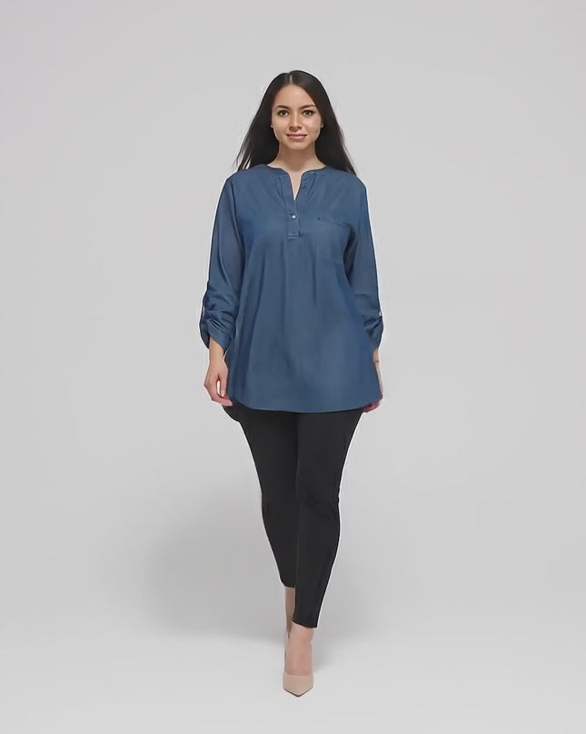 Студийно видео, в което плюс сайз модел върви бавно към камерата, облечена в Дамска дънкова риза с джобче в големи размери