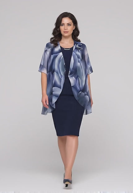 Продуктово видео в студийна среда, показващо Официална тъмносиня рокля от две части с шифонена пелерина, облечена от макси модел, който върви бавно към камерата