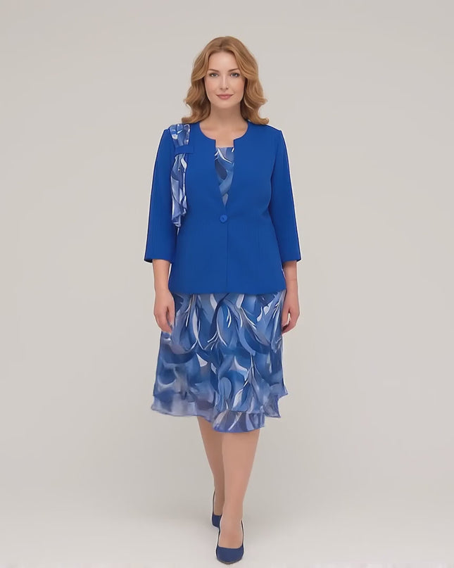 Видео в студийна среда, показващо плюс сайз модел, който върви бавно към камерата и носи Официален дамски костюм големи размери с шифонена рокля в кралскосин цвят