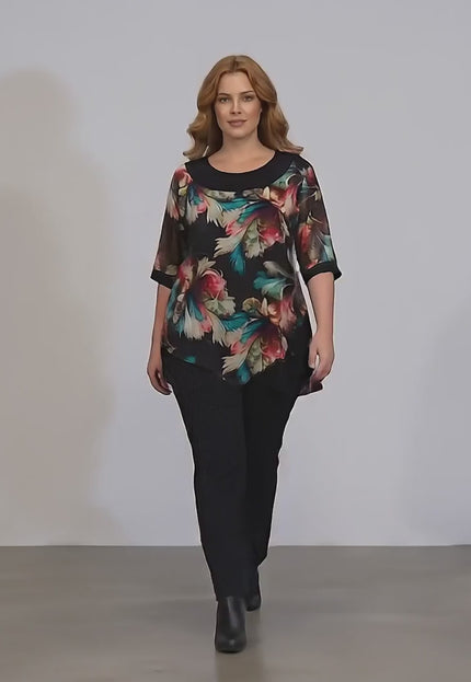 Плюс сайз модел в студийна среда с неутрален фон върви бавно към камерата, носейки Официална туника с шарен шифон и тюл в  големи размери