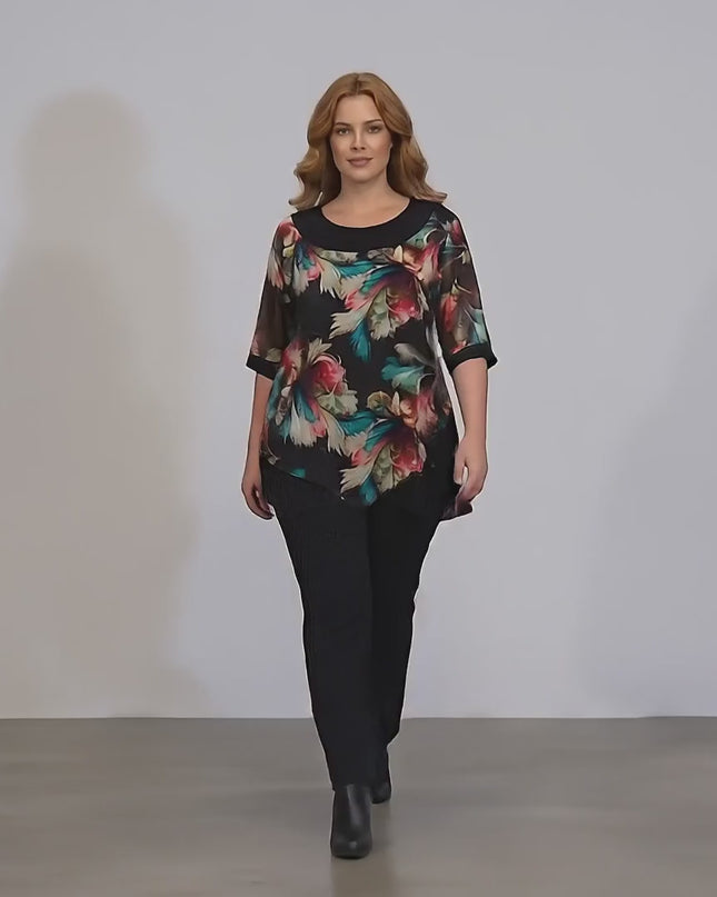 Плюс сайз модел в студийна среда с неутрален фон върви бавно към камерата, носейки Официална туника с шарен шифон и тюл в  големи размери