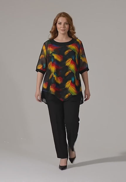 Видео представяне в студио на Официална макси туника с асиметричен пъстър шифон в черно, носена от макси модел, който върви бавно към камерата на неутрален фон