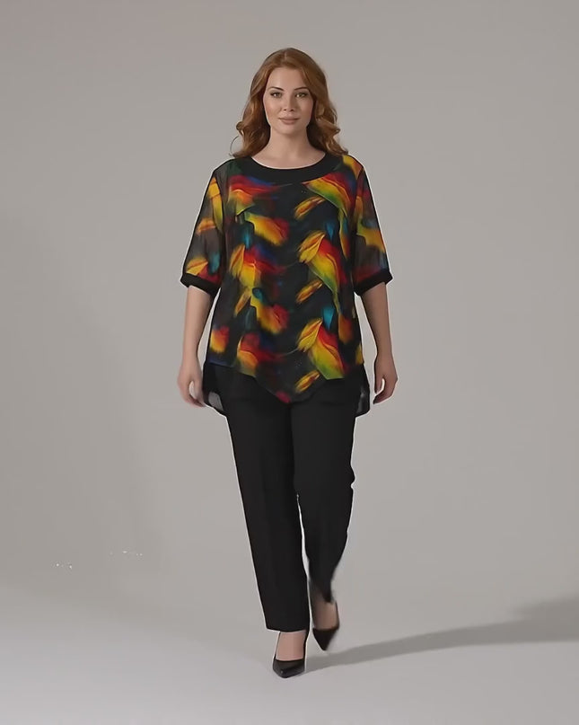 Видео представяне в студио на Официална макси туника с асиметричен пъстър шифон в черно, носена от макси модел, който върви бавно към камерата на неутрален фон