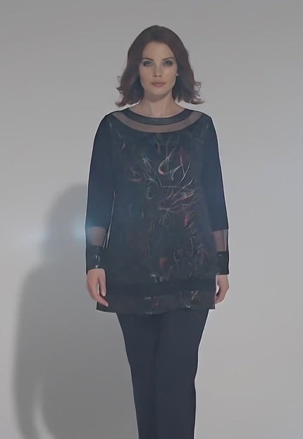 Продуктово видео в студио с неутрален фон, на което плюс сайз модел носи Официална черна туника големи размери с ефектно деколте и върви бавно към камерата