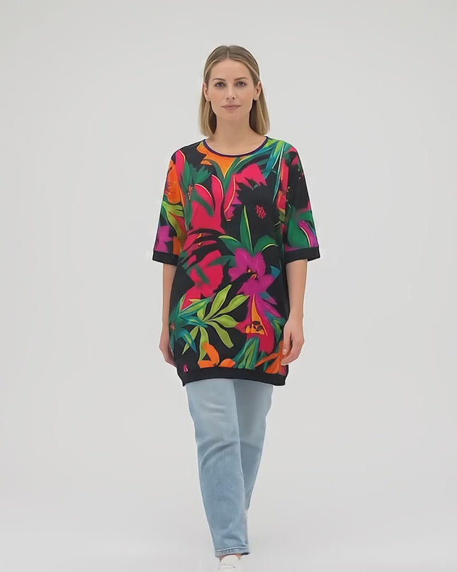 Продуктово видео в студио, показващо плюс сайз модел на неутрален фон, който върви бавно към камерата и е облечен с Шарена лятна туника големи размери с джобчета