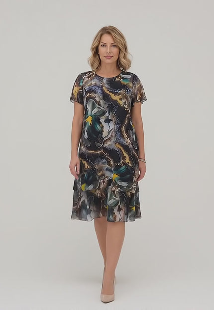 Видео представяне в студио на неутрален фон, където плюс сайз модел върви бавно към камерата, облечена в Официална разкроена макси рокля от шифон с многоцветен принт