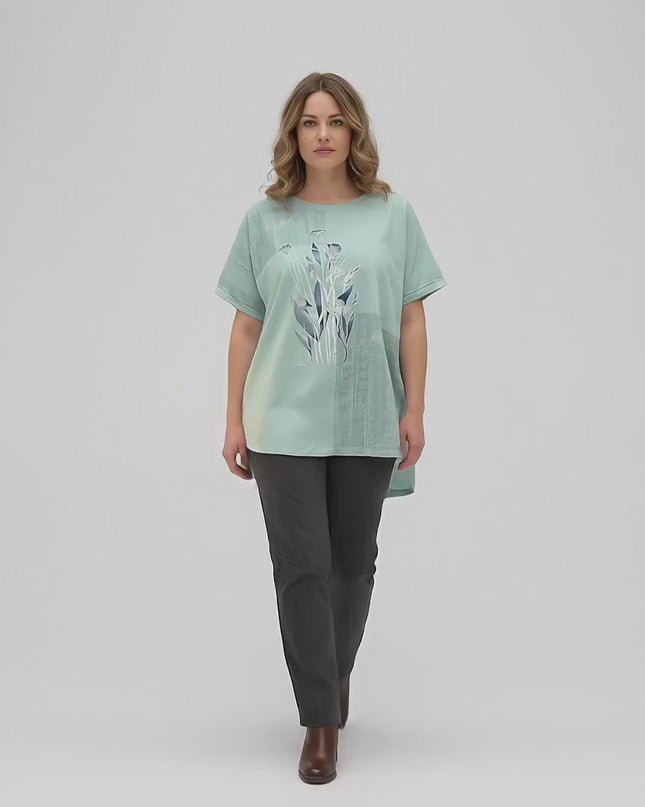 Студийно видео представяне на неутрален фон, в което плюс сайз модел върви бавно към камерата, облечена в Ежедневна памучна туника големи размери в зелено