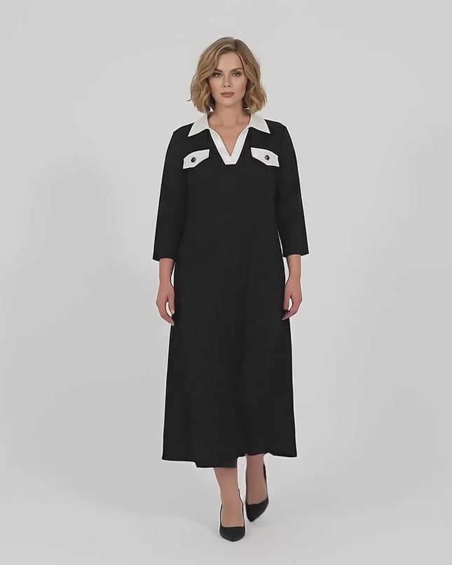 В студийна среда на неутрален фон макси модел върви бавно към камерата облечена в Черна официална макси рокля големи размери с контрастна яка