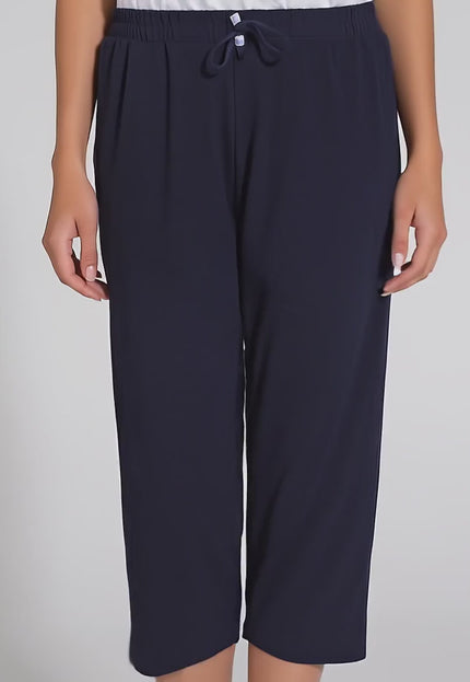 Продуктово видео в студийна среда на неутрален фон, показващо плюс сайз модел, който върви бавно към камерата и носи Дамски панталони в големи размери - Еластични