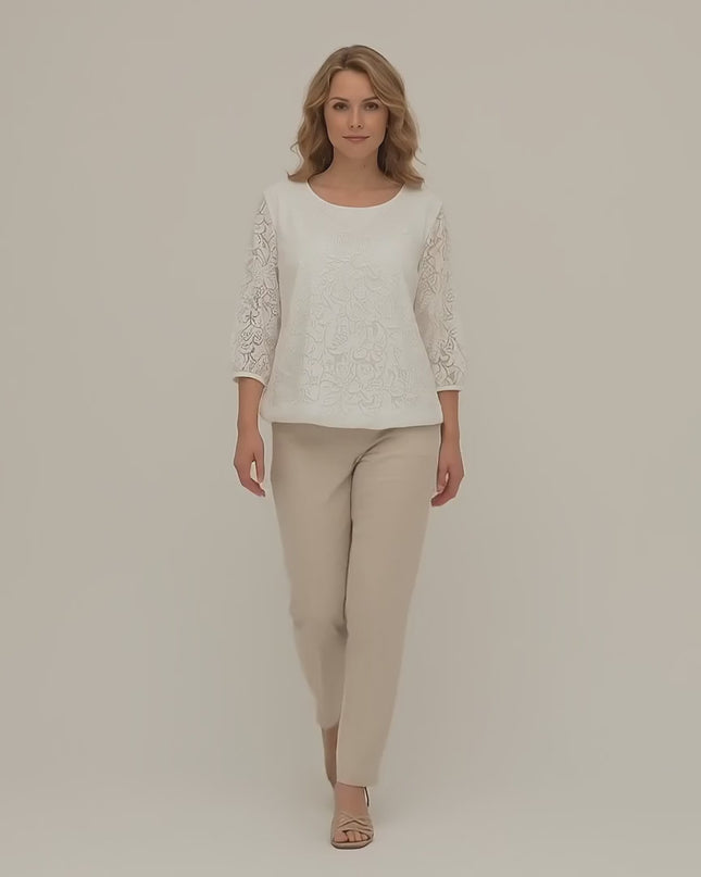 Модел плюс размер е облечен с Официална бяла макси туника с флорален десен и върви бавно към камерата в студийна среда на неутрален фон