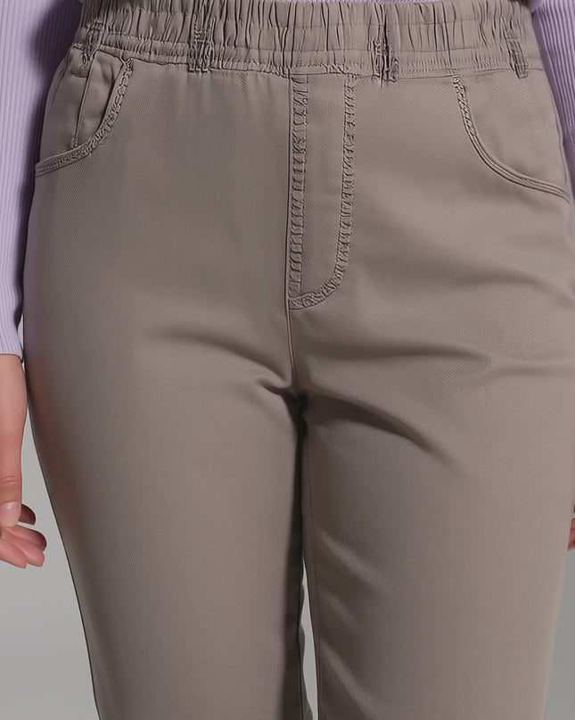 Видео в студийна среда, показващо модел, който върви бавно към камерата и носи Бежови дамски дънки големи размери с права кройка