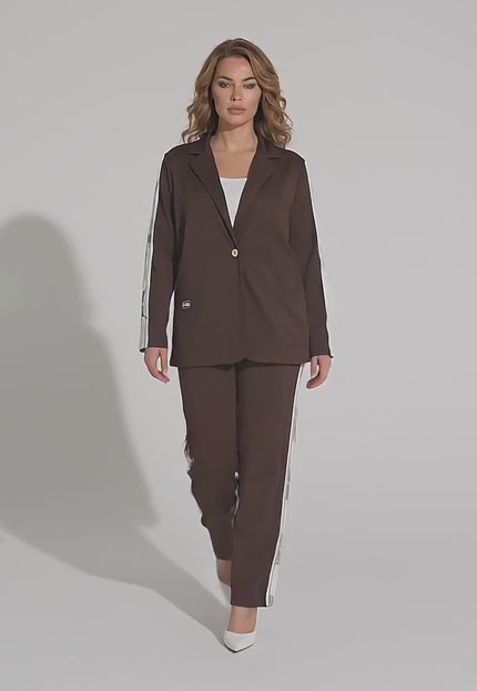 Студийно видео с неутрален фон, в което макси модел върви бавно към камерата, носейки Официален дамски комплект от две части в кафяв цвят