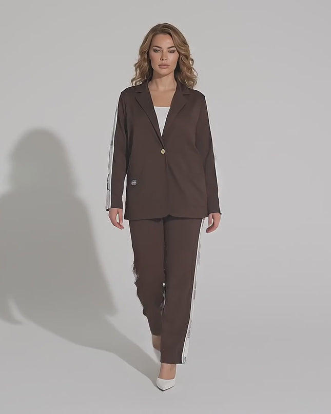 Студийно видео с неутрален фон, в което макси модел върви бавно към камерата, носейки Официален дамски комплект от две части в кафяв цвят