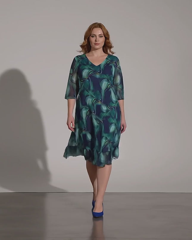 Продуктово видео в студийна среда, показващо как модел носи Официална шифонена рокля големи размери в преливащи сини тонове и върви бавно към камерата