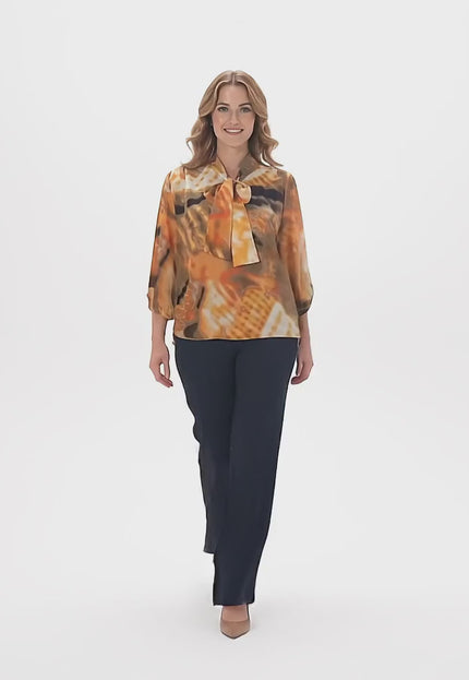 Студийно видео, в което плюс размер модел върви бавно към камерата и носи Официална оранжева туника с панделка и ластичен подгъв големи размери