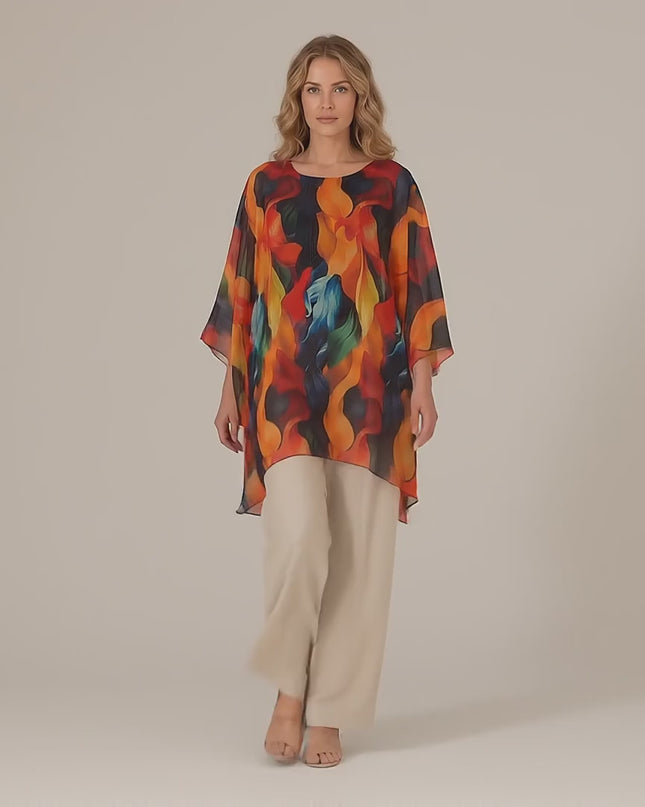 Плюс сайз модел, облечен с Официална лятна макси туника тип пончо в пъстър десен, се разхожда бавно към камерата на неутрален фон в студийна среда